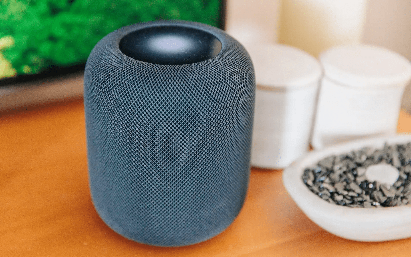 a grey speaker on a brown table