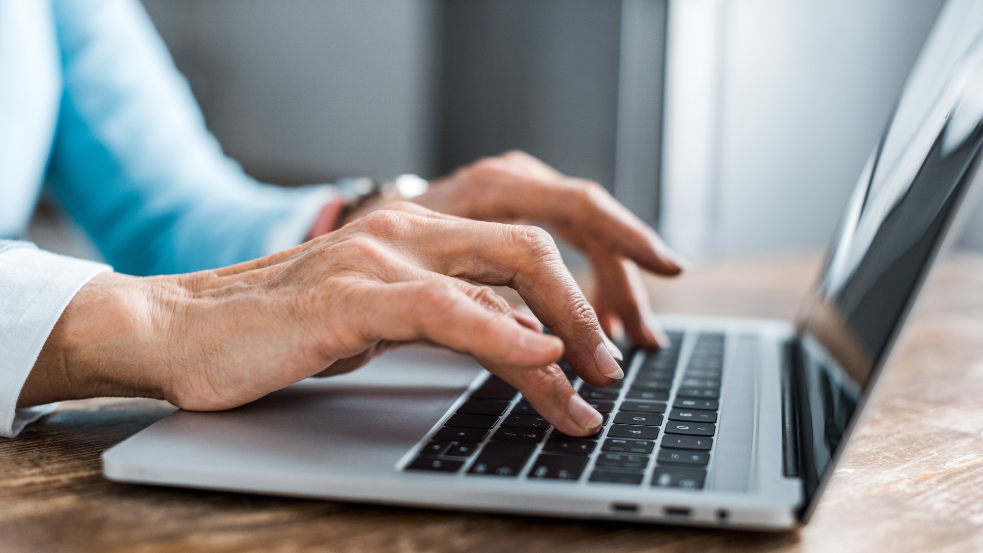 Woman's hands typing on laptop