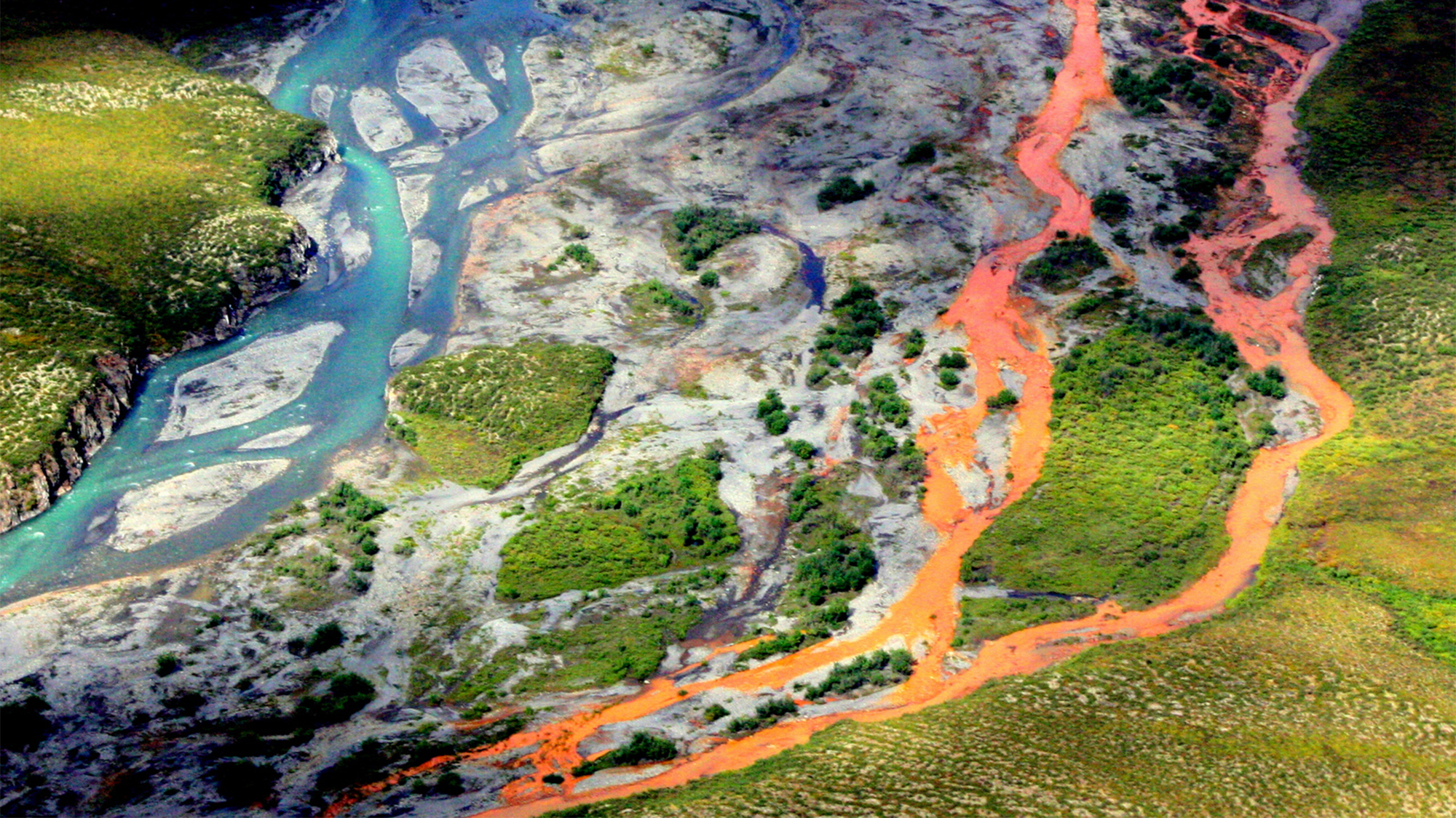 An aerial view of the rust-colored Kutuk River in Gates of the Arctic National Park in Alaska. Thawing permafrost is exposing minerals to weathering, increasing the acidity of the water, which releases metals like iron, zinc, and copper.