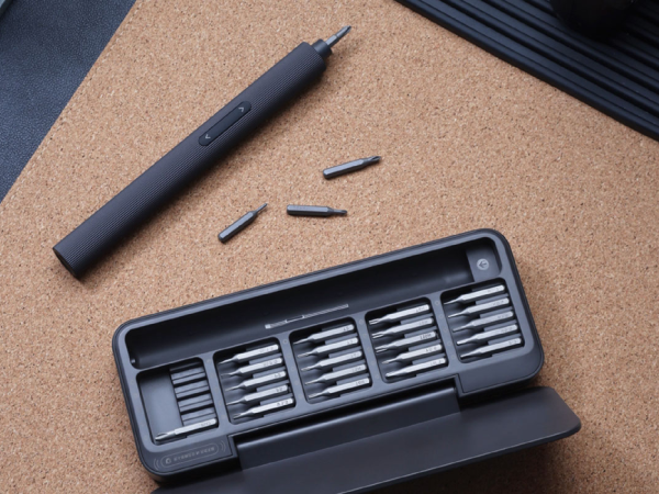 An electric screwdriver set on a cork board.