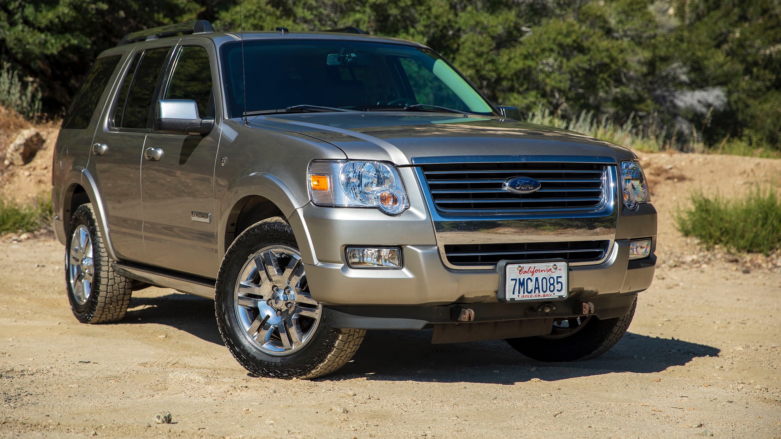 an suv with its tires turned out on a dirt road