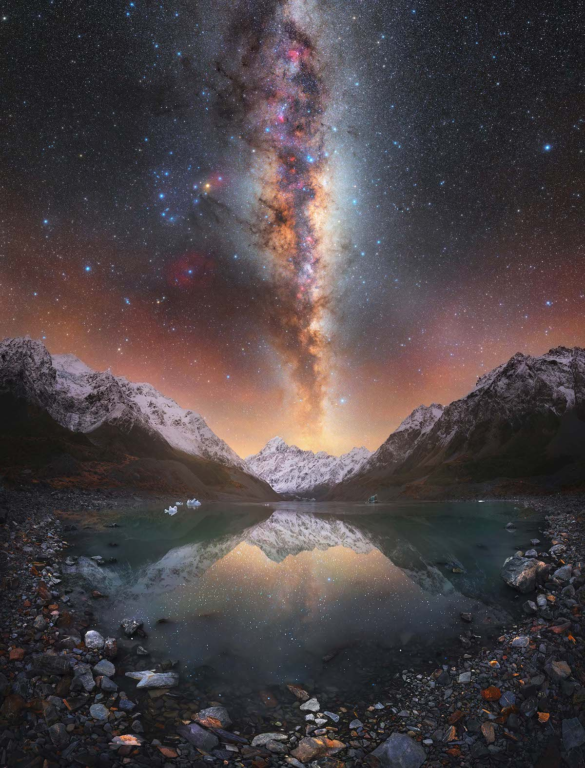 a mountain lake with a colorful milky way in the sky