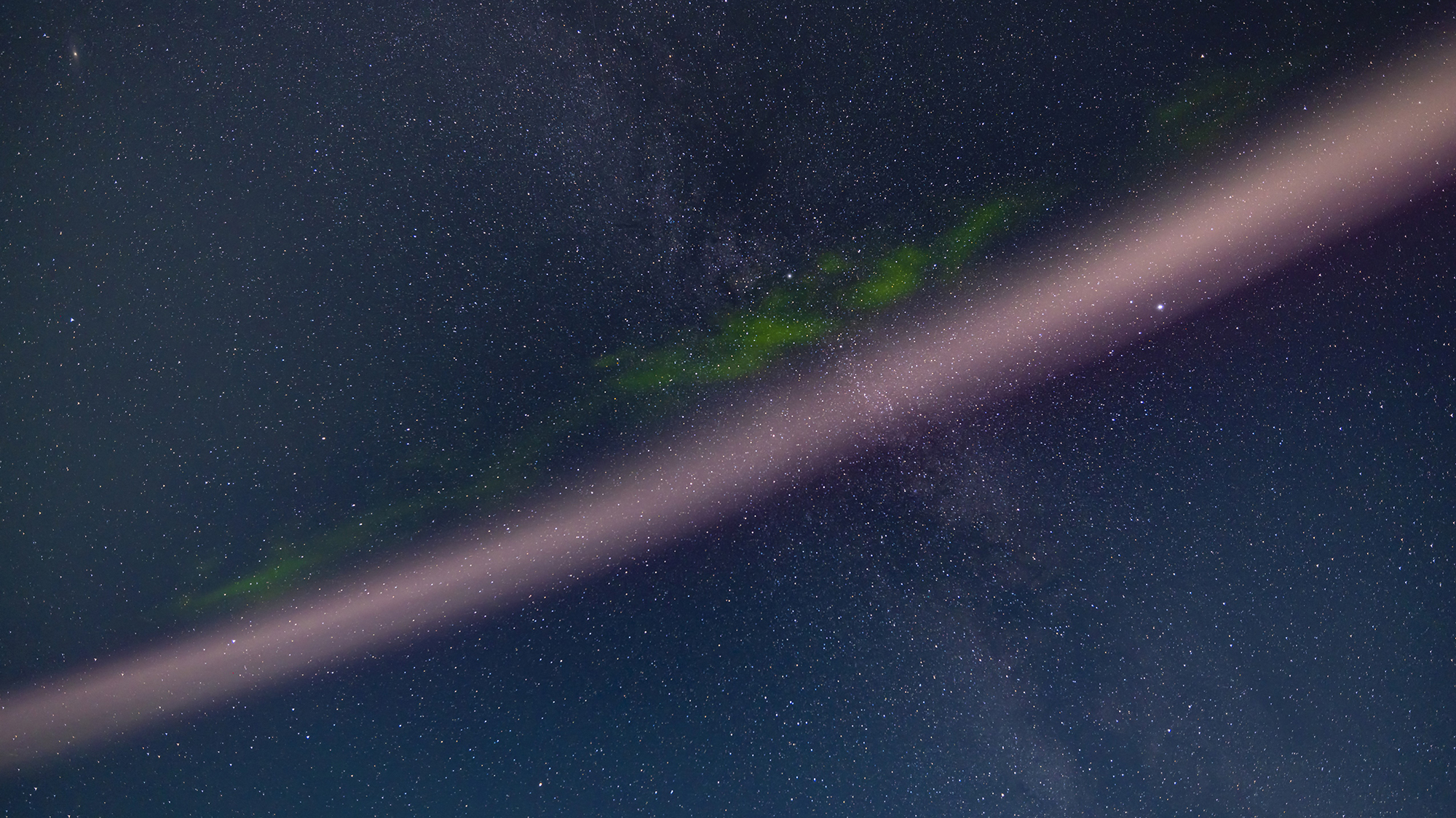 A portrait of the infamous STEVE arc of hot flowing gas associated with an active aurora, here showing his distinctive pink colour and the fleeting appearance of the green picket fence fingers that often show up hanging down from the main arc. On this night the green fingers lasted no more than two minutes. STEVE = Strong Thermal Emission Velocity Enhancement, and is a river of hot gas flowing east to west equatorward of the main aurora band. This is a tracked single image looking straight up, and framing the Summer Triangle stars at right and the Milky Way. Moonlight from the setting waxing gibbous Moon lights the sky, as does the bright aurora to the north. (Photo by: Alan Dyer/VW Pics/Universal Images Group via Getty Images)