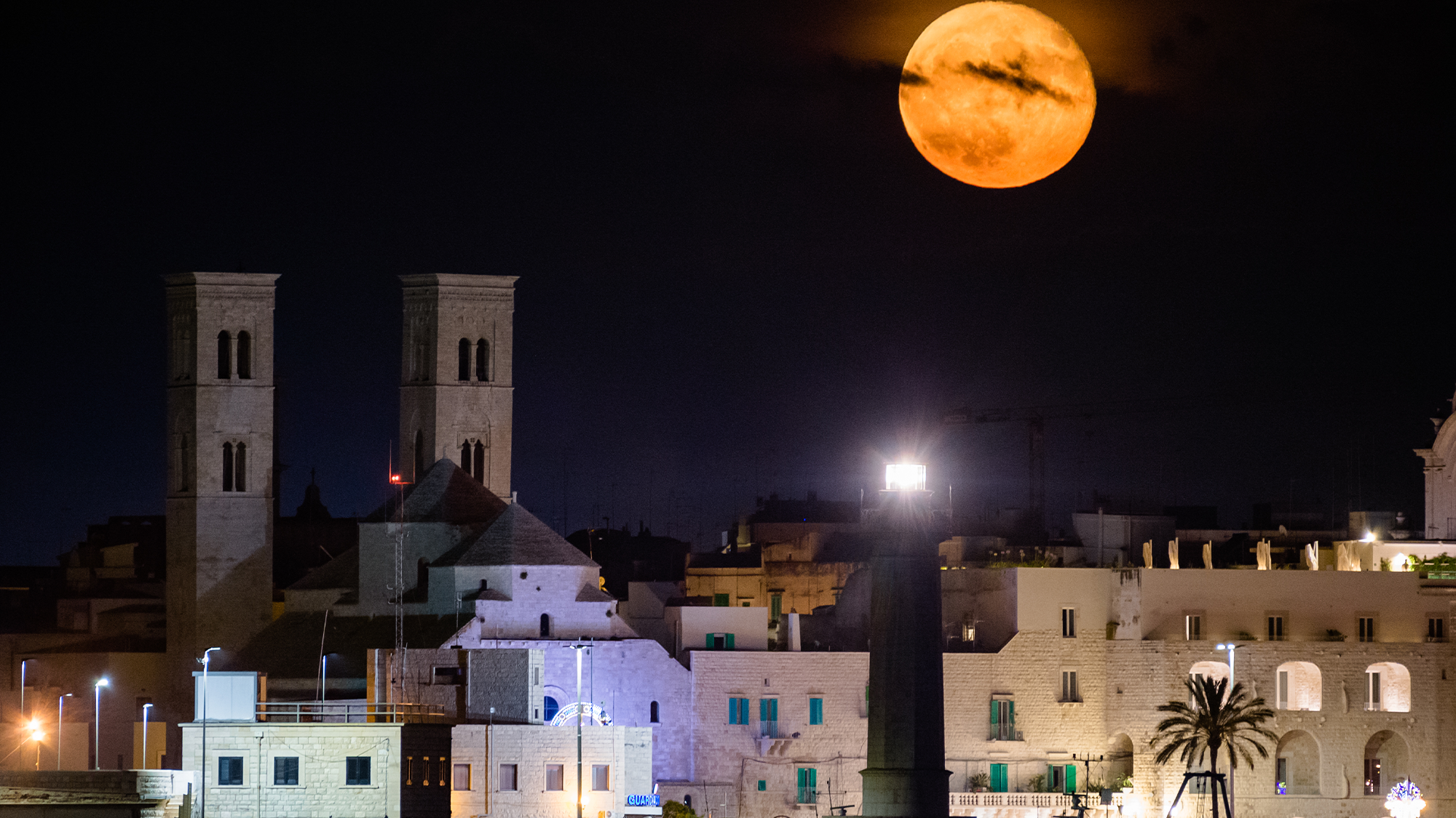 a fun moon rises over an italian city