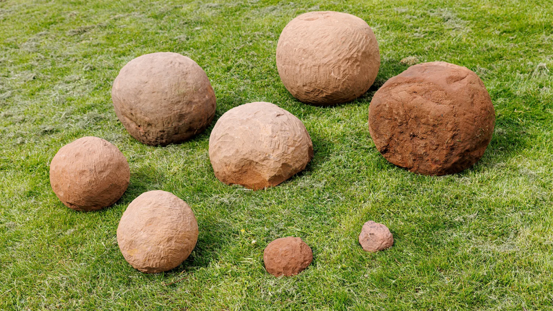 eight catapult stones on grass