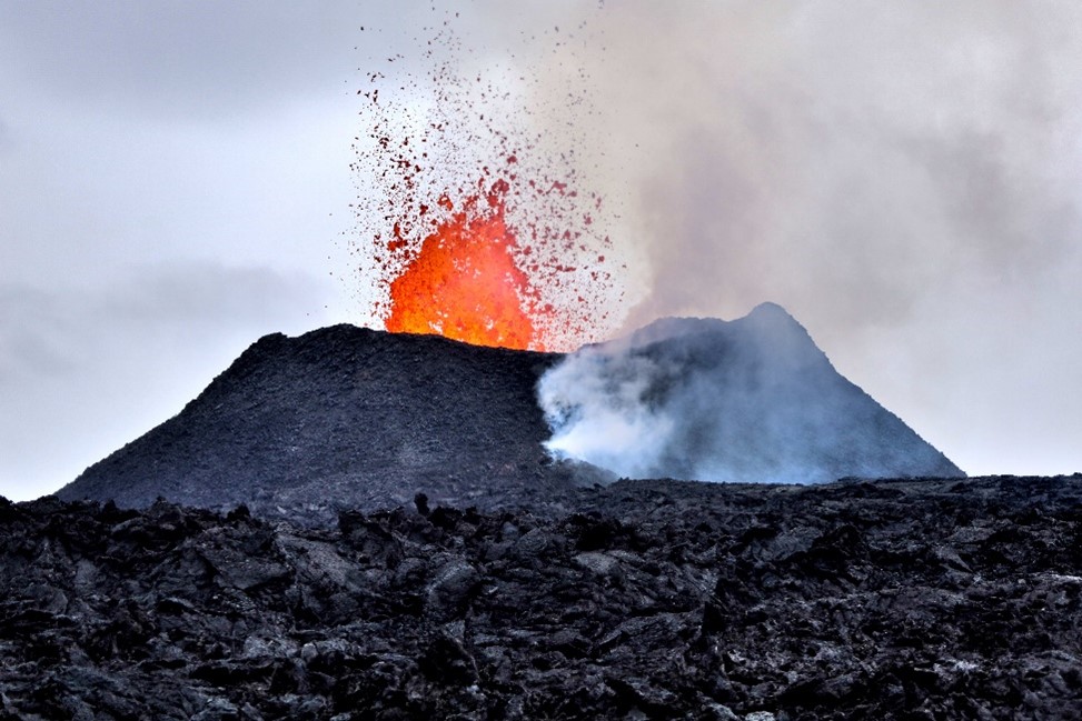 a volcano in iceland spews orange lava 