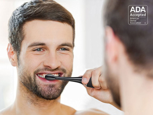 A person brushing their teeth with a AquaSonic Black Series Toothbrush