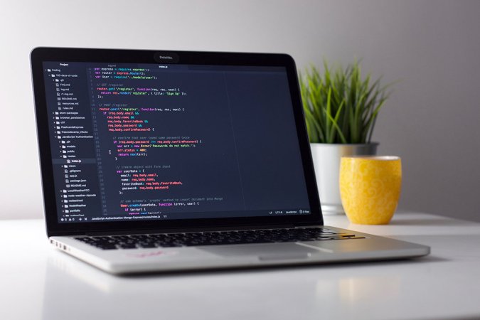 A laptop sitting on a table with code open on it