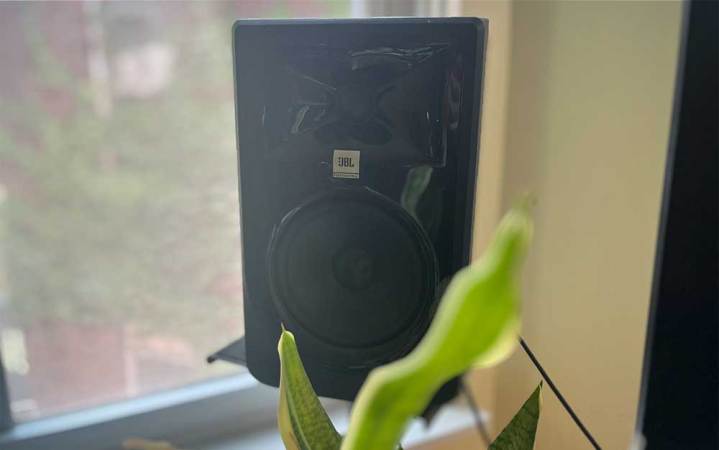  A JBL LSR 305P MKII studio monitor on a monitor stand in a at-home music production studio. 
