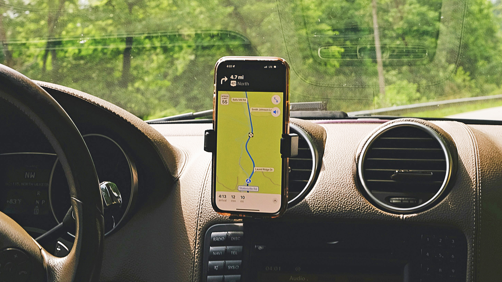 a smartphone with a map open on the dashboard of a car