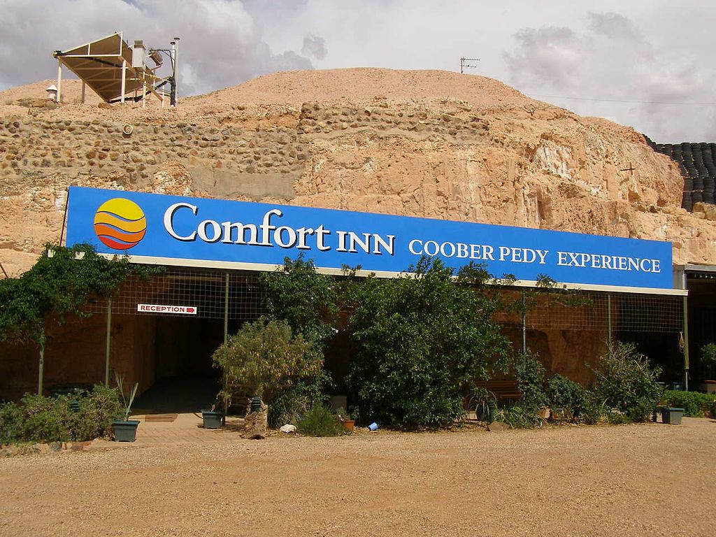 a hotel built into a wall of rock. a "comfort inn" sign on the outside 