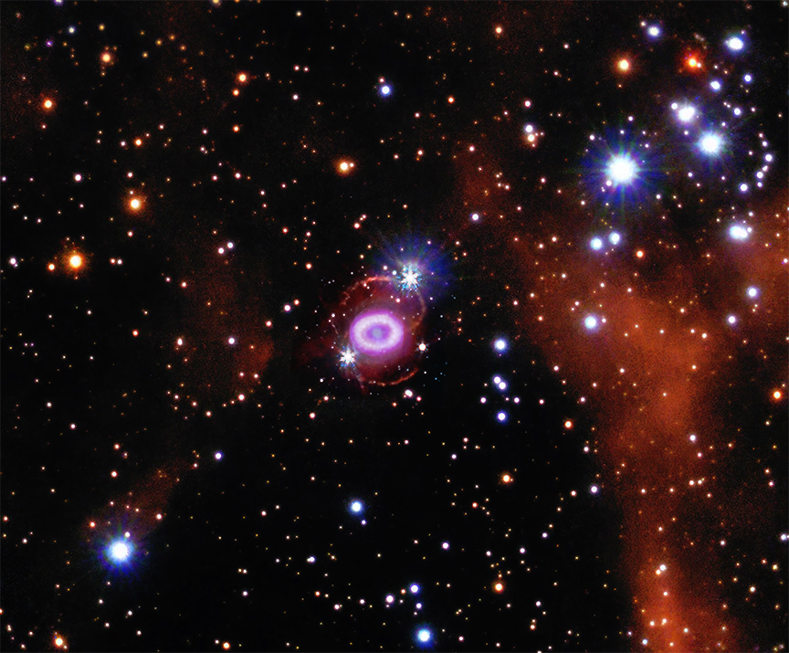 At the center of this composite image is a small object resembling a glowing pink Cheerio. Inside this ring is a pale, steel blue dot containing debris from the star that exploded.. The ring sits at the center of a ghostly figure 8, outlined in brick orange. This entire structure is surrounded by a packed field of stars, specks and dots in white, blue, and orange.