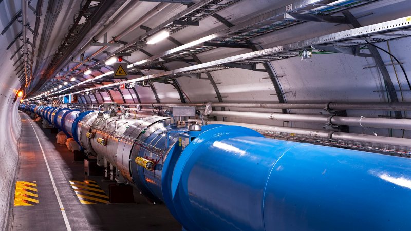 Particles rush through a long tunnel in the Large Hadron Collider.