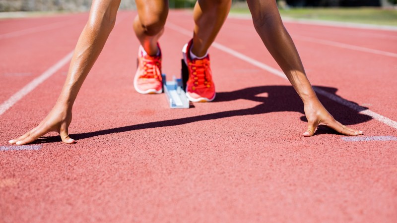 Close up of woman in runner's stance on track