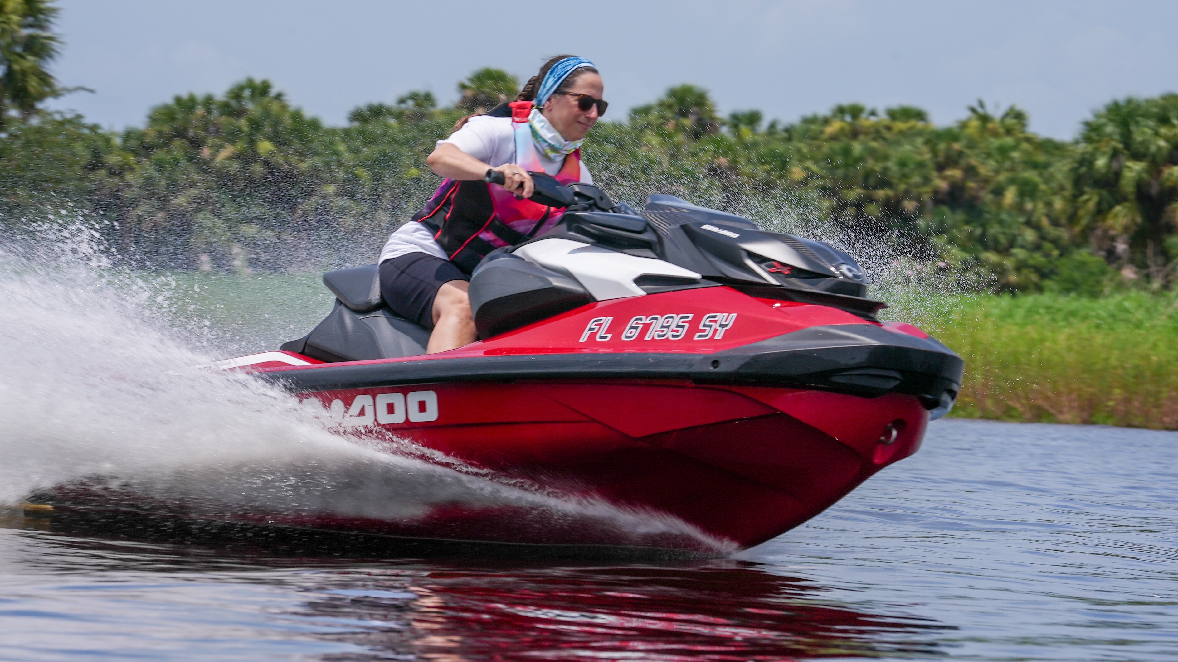 woman riding a sea-doo watercraft on a brown river