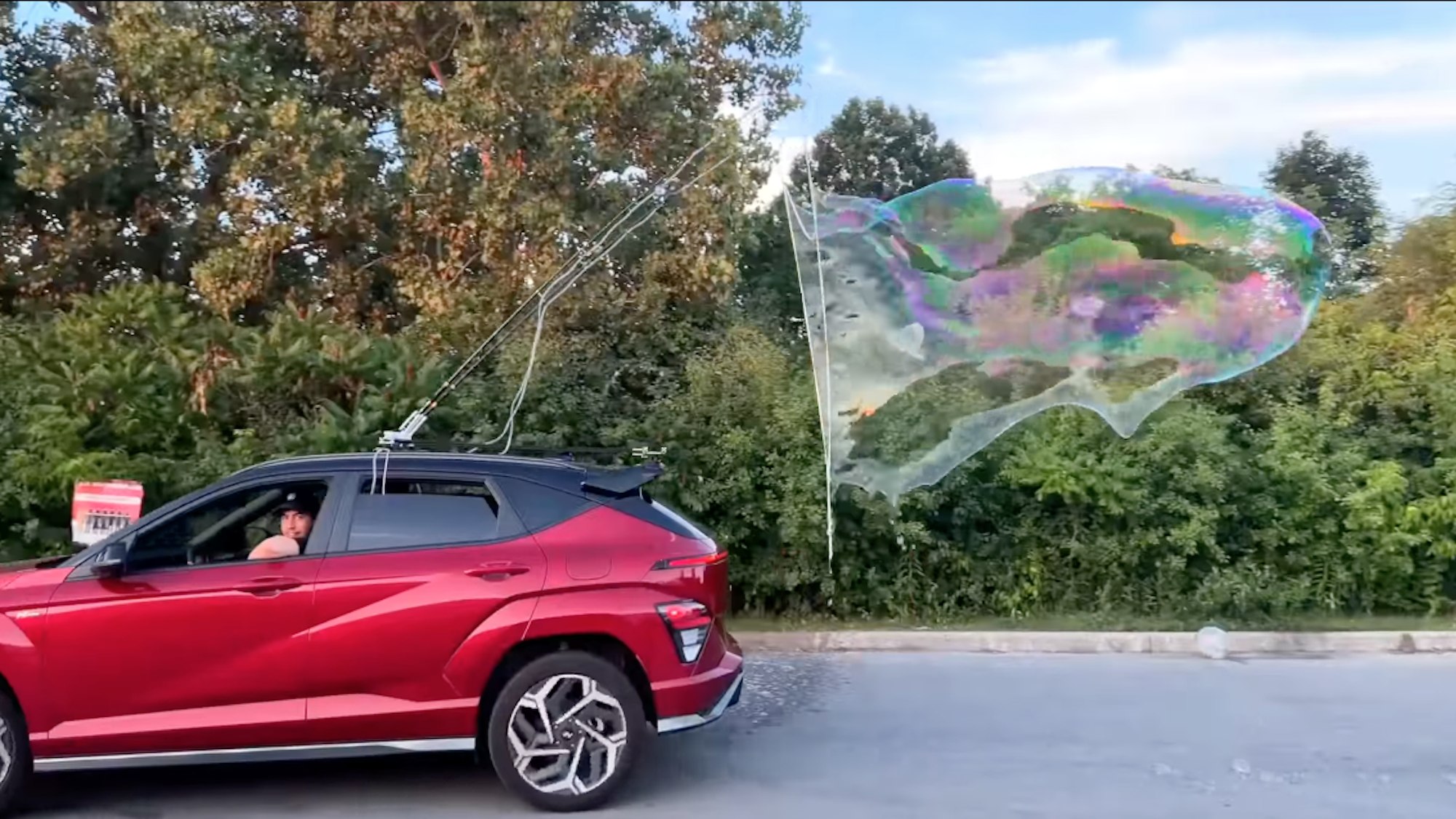 Soap bubble machine on top of car blowing a large bubble