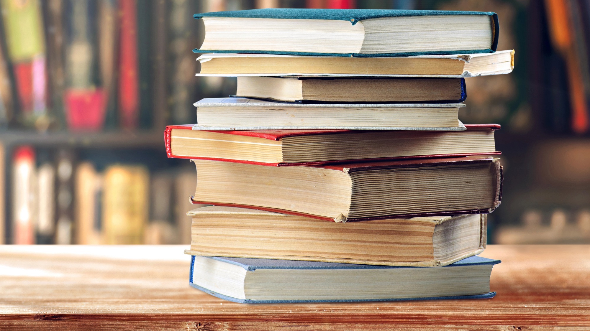 a pile of books on a wooden table