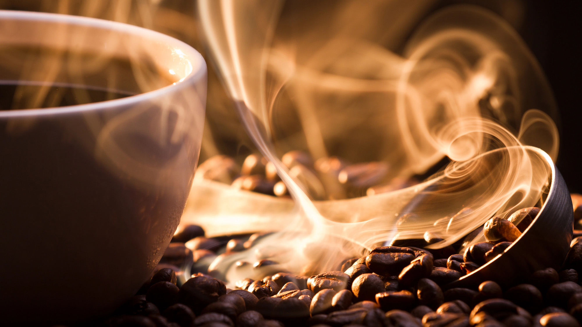 pile of coffee beans and a steaming cup of coffee