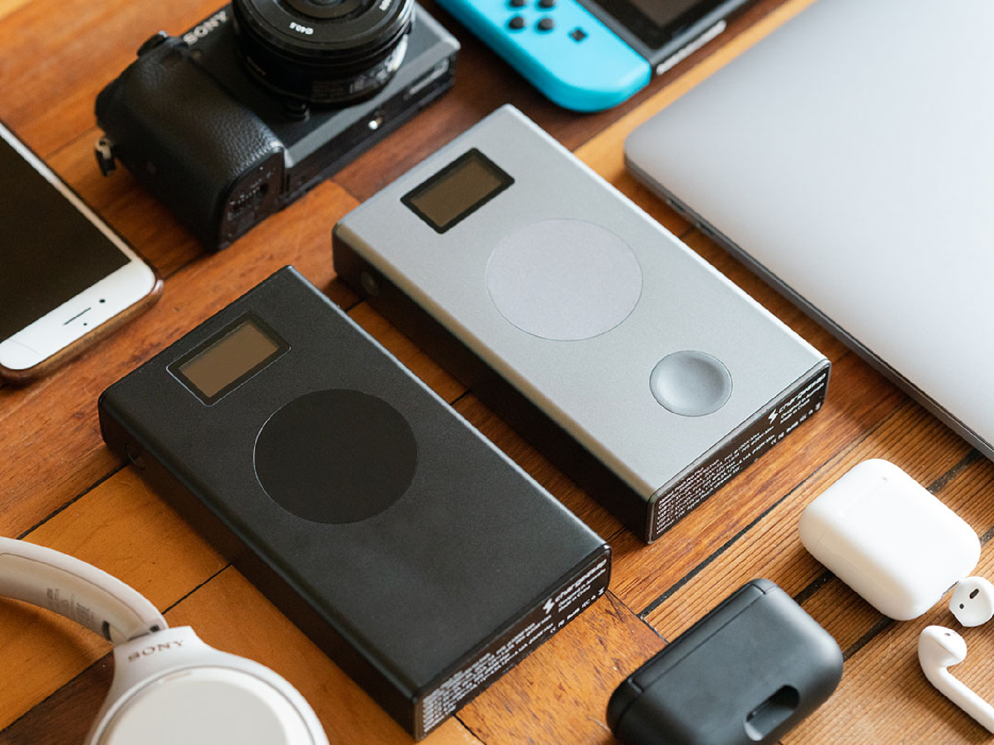 A power bank and electronics sitting on a desk.