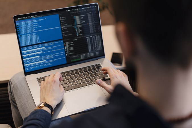 A person coding on their MacBook Pro.