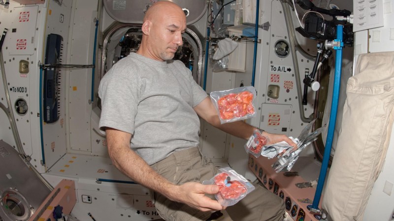 European Space Agency astronaut Luca Parmitano, Expedition 36 flight engineer, is pictured near food packages floating freely in the Unity node of the International Space Station.