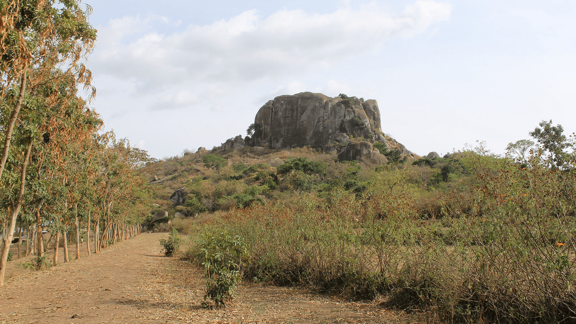 Located in the foothills of a rock emerging from a green field