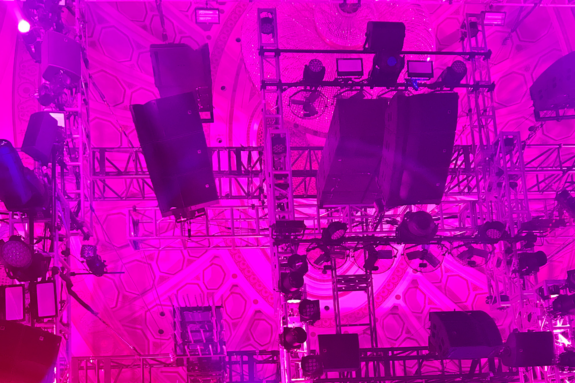 A view of speakers hanging from the ceiling of the Broadway Theatre from the "dancefloor" during a production of Here Lies Love