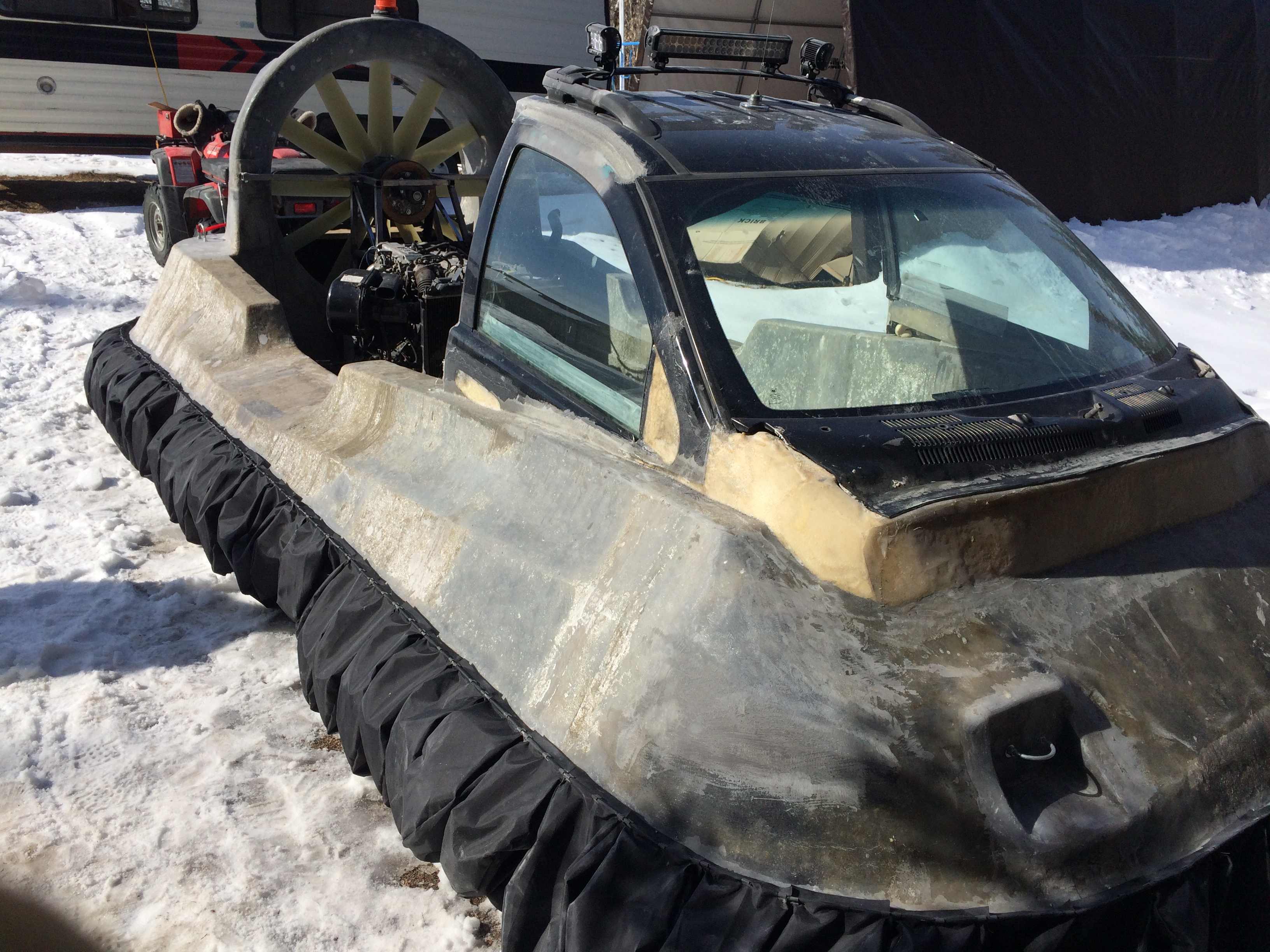 a grey hull of a hovercraft with the windshield of a car attached