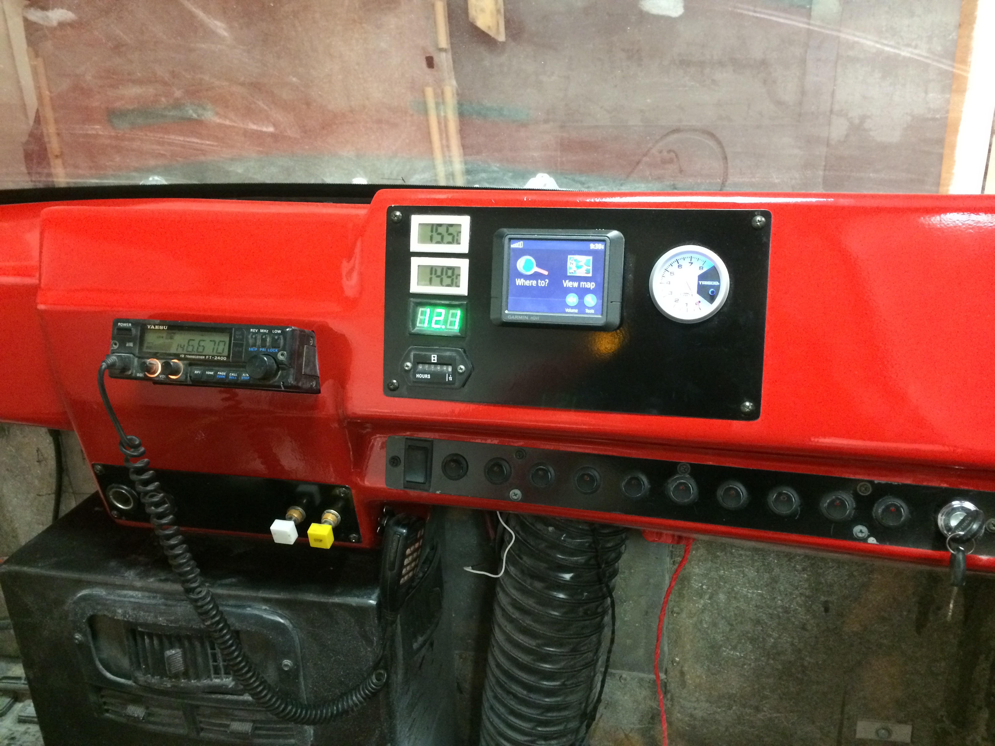 the front dash of a hovercraft showing a ham radio and various wires and tubes