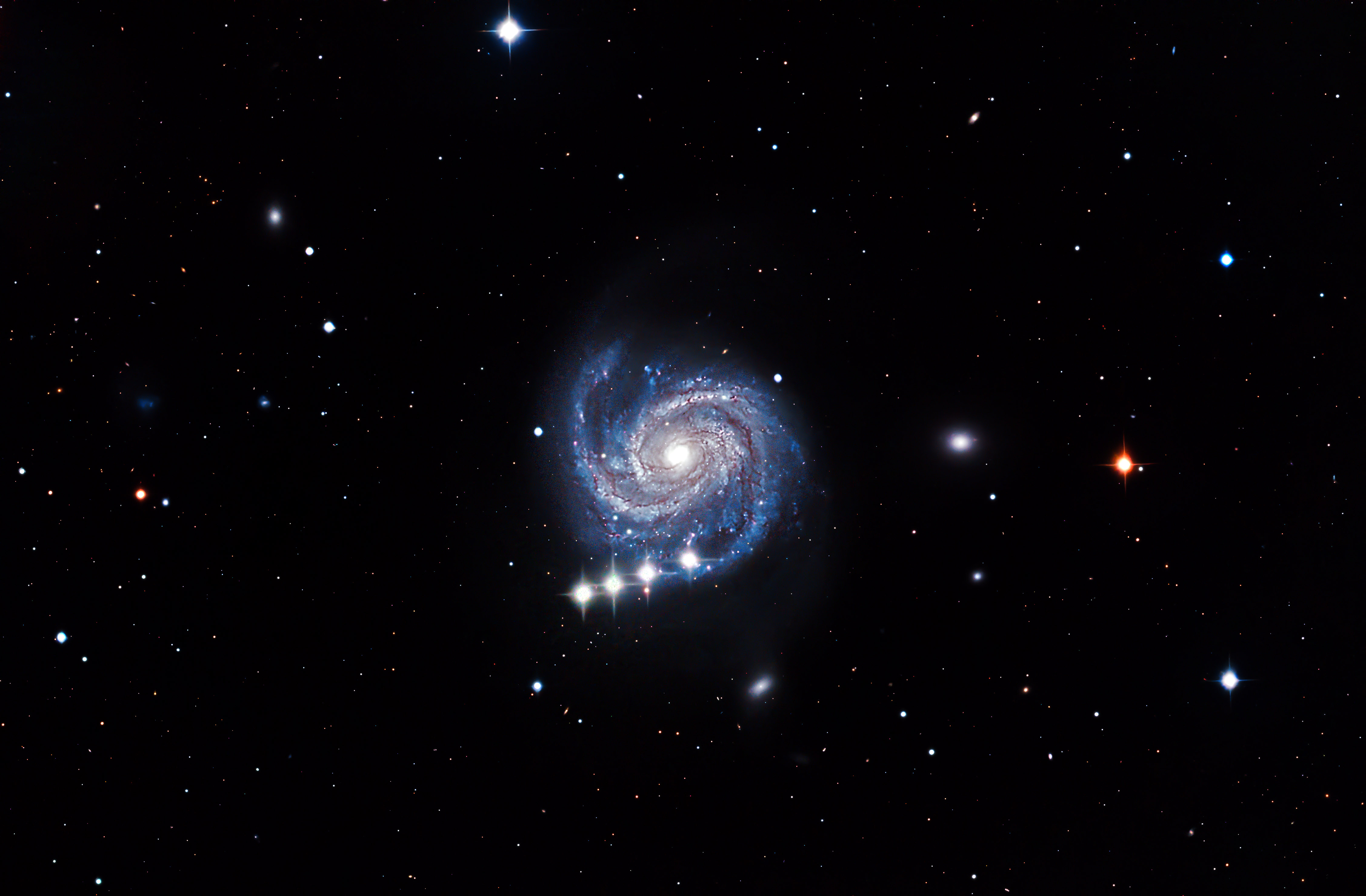 a swirling galaxy on black sky with bright stars