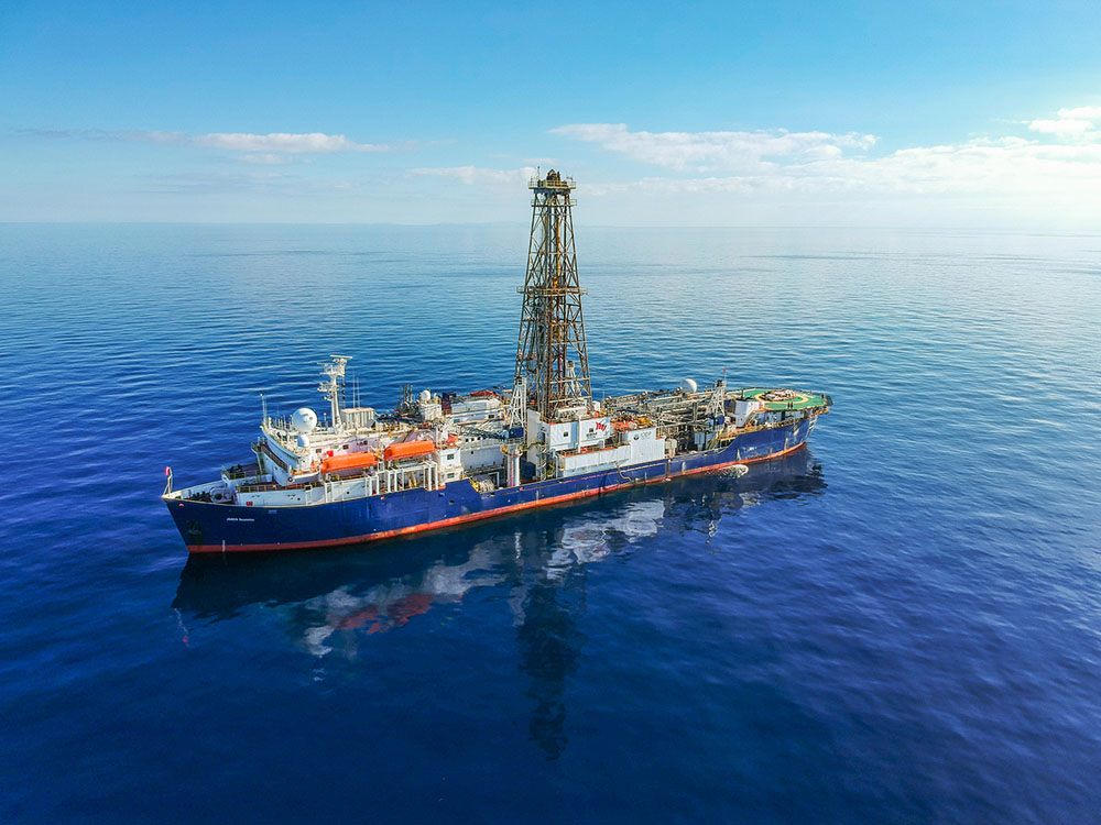 een groot schip uitgerust met een boor om sedimentkernen onder de oceaan in zee te halen