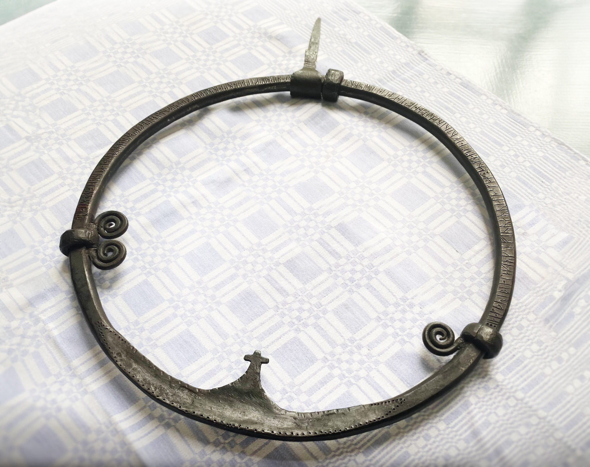 a large iron ring with ancient scandanavian runes etched in