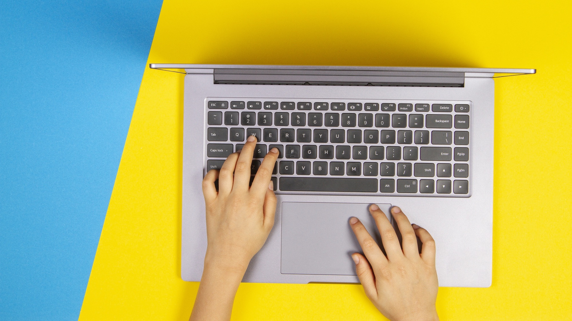 children's hands typing on a laptop