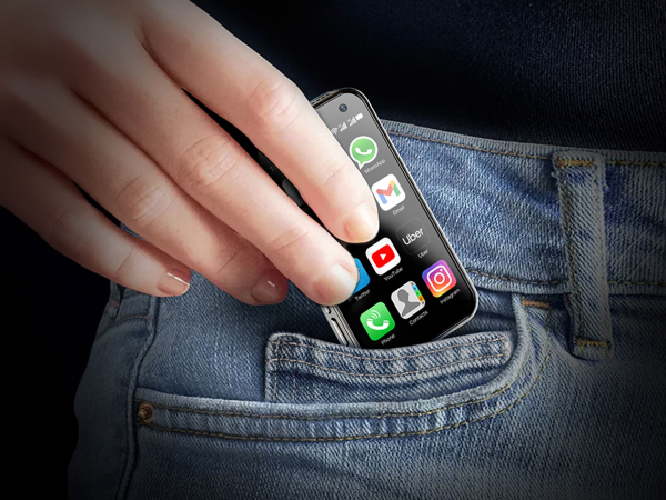 A person putting a small phone in their pocket.