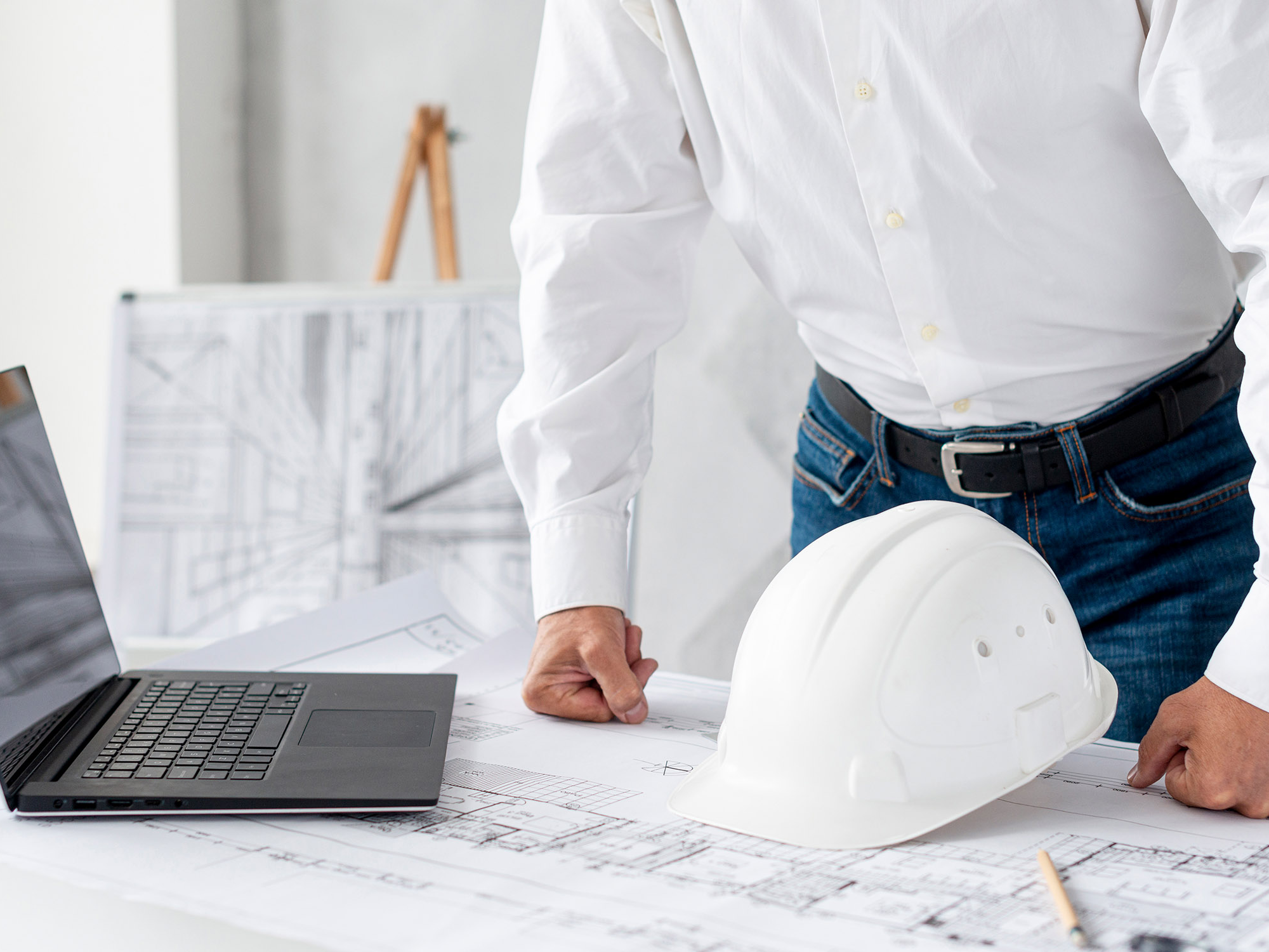 A person using construction software and standing at a marble counter.