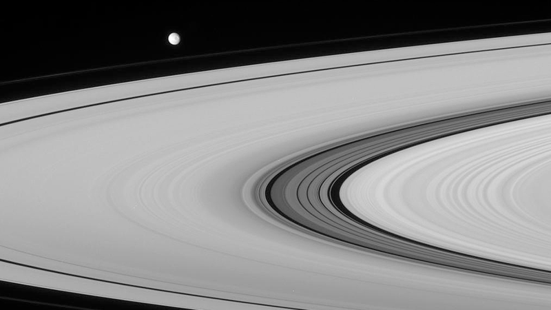 Saturn’s moon Mimas, floating above the planet’s rings, might conceal a liquid ocean beneath its surface.