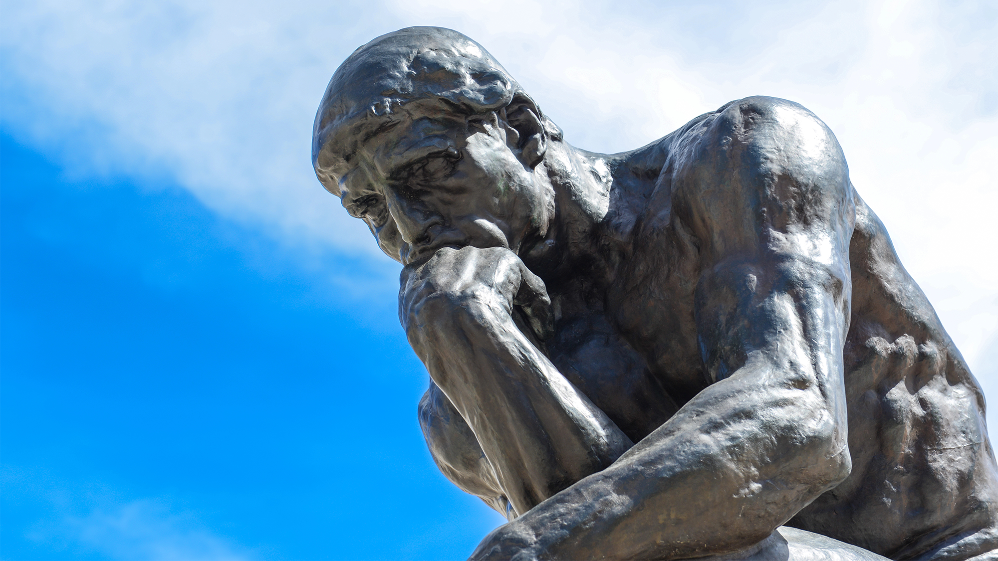 a sculpture of a man hunched over leaning on a balled fist called 'the thinker'