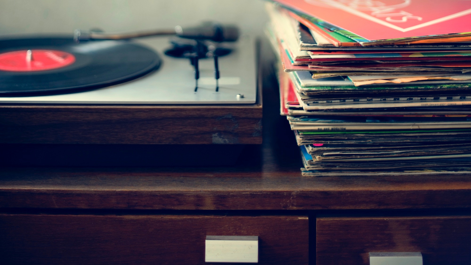 vinyl records in a pile next to a record player