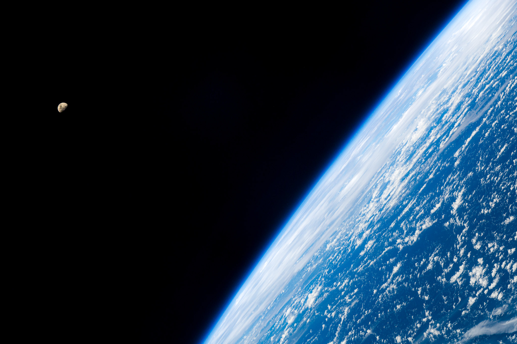 la tierra se ve muy grande desde el costado del camino con una media luna contra el cielo negro a la izquierda