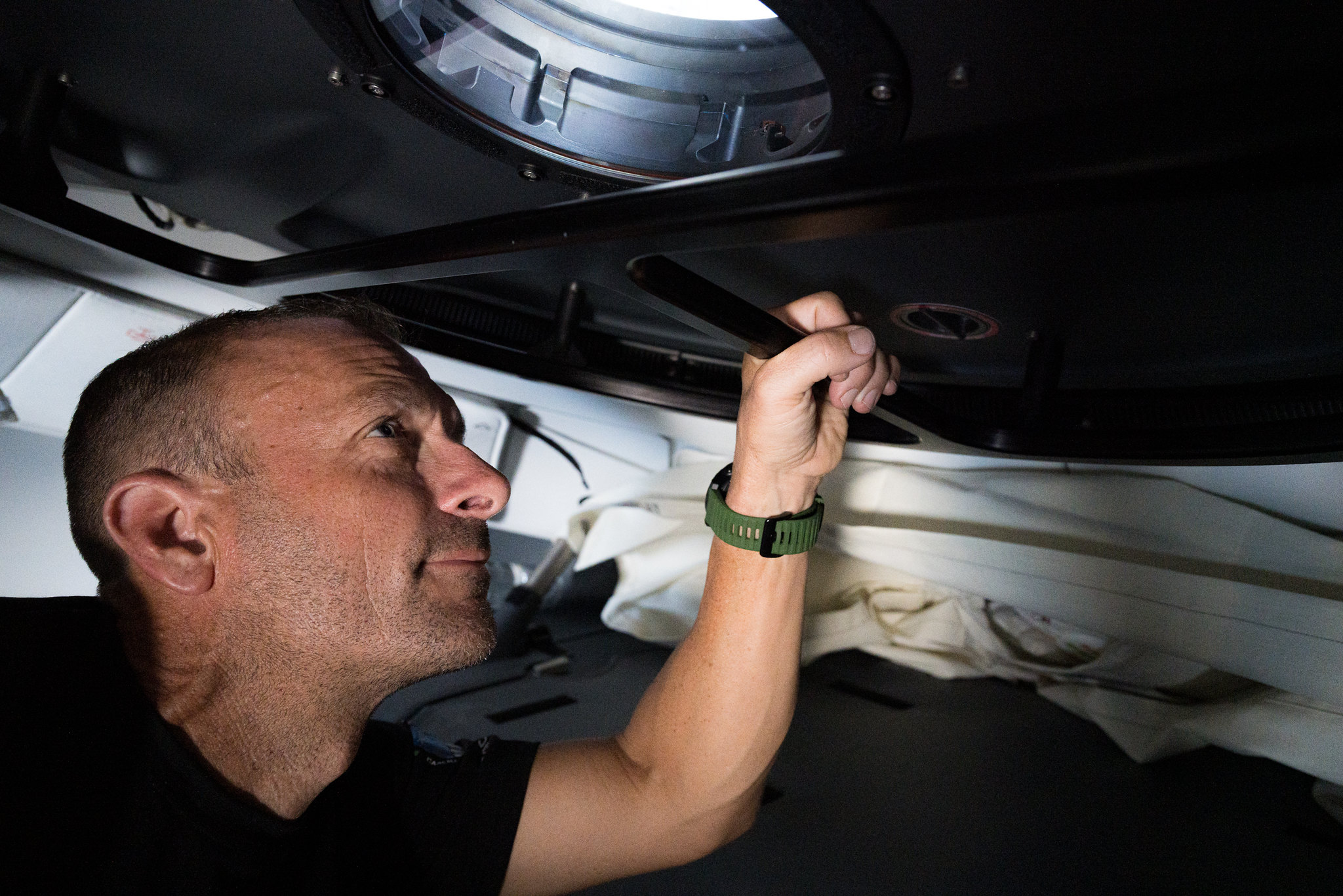 a man holds a door on space capsule