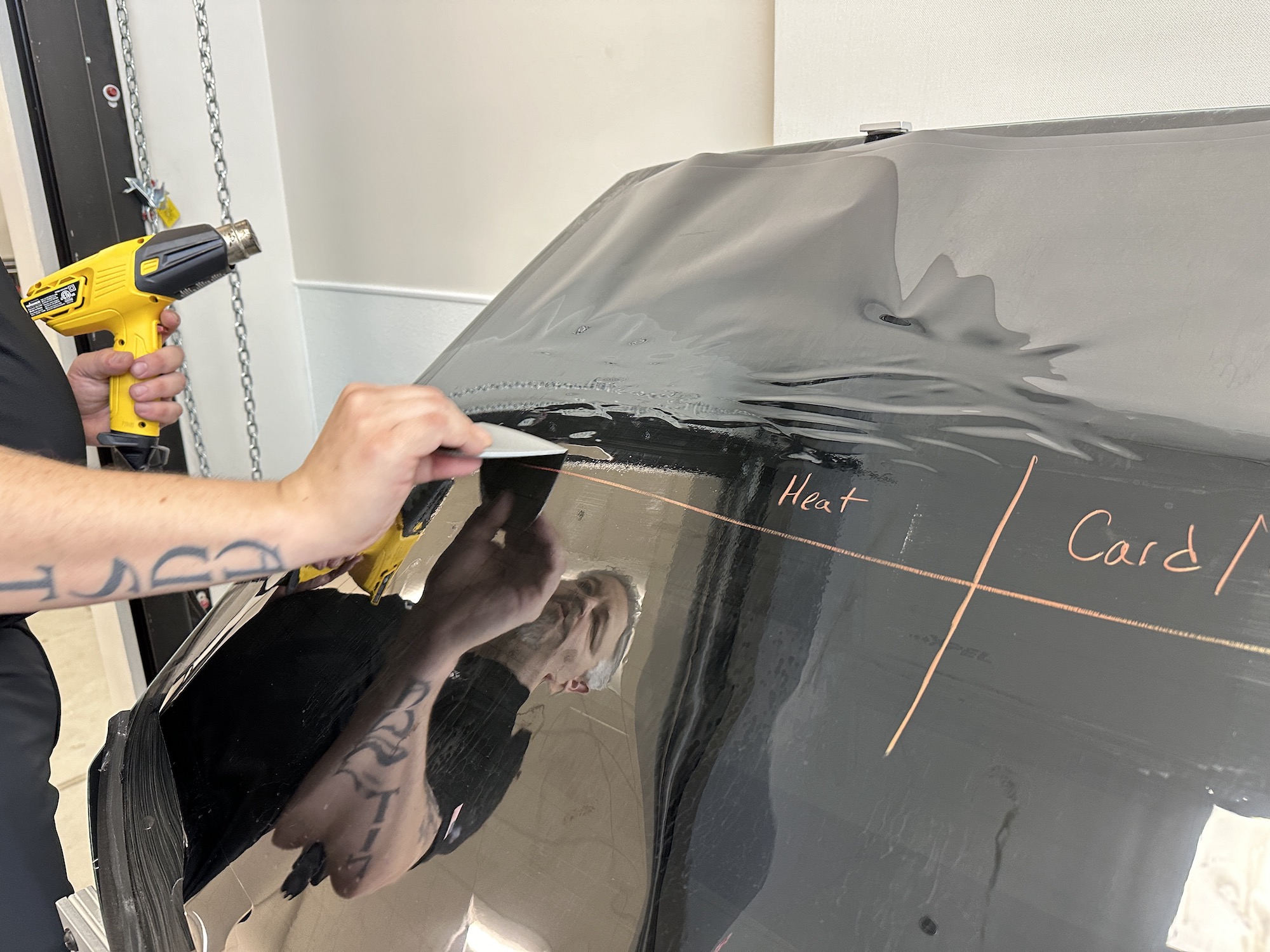 a man applies a protective coating to a car part