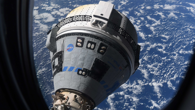 Starliner docked with ISS with Earth in background