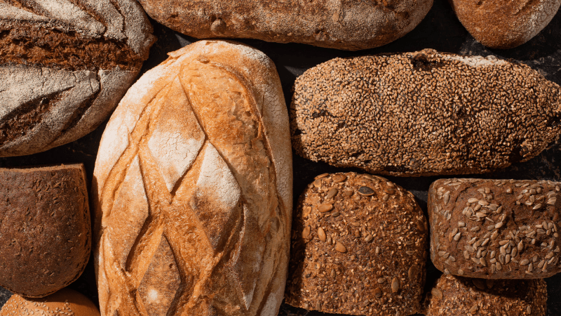 several loaves of golden rustic looking bread on a table