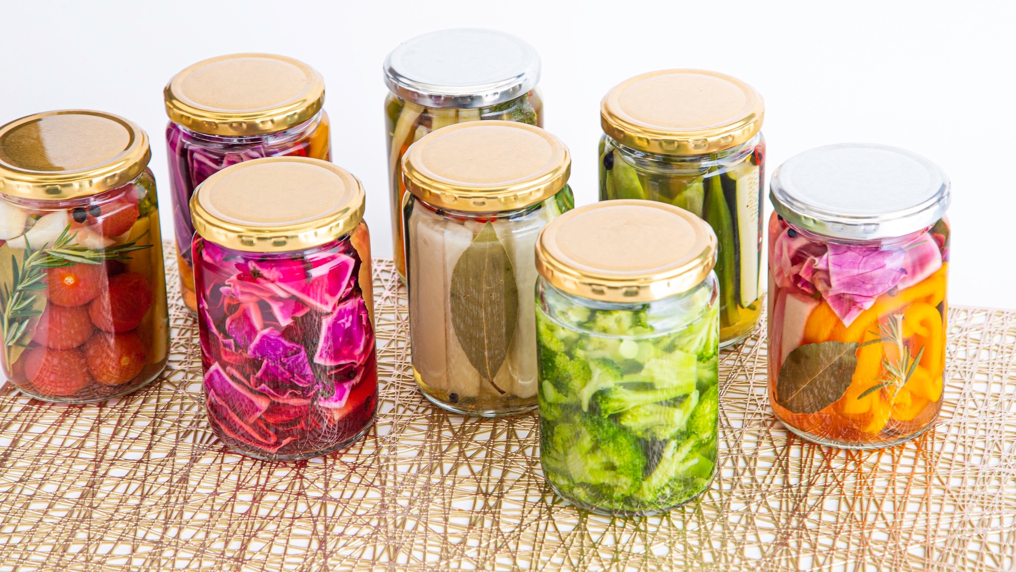 jars filled with different types of fruits and vegetables in liquid