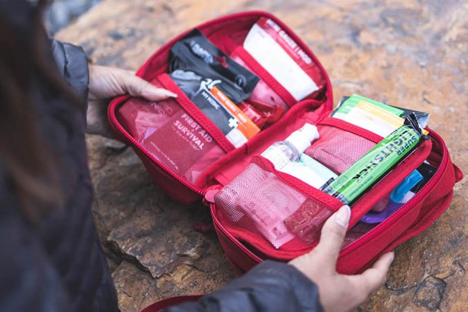 A person opening a first aid kit.