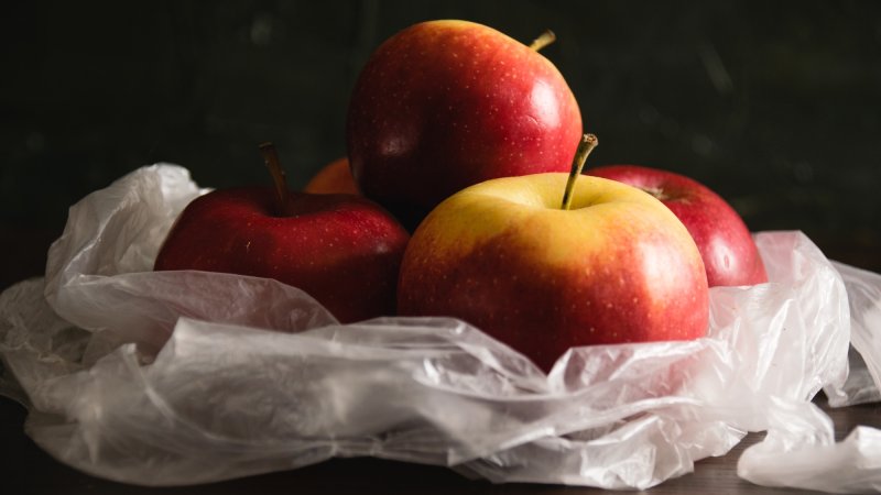 Delicious apples in a plastic bag. Earth day and waste recycling concept