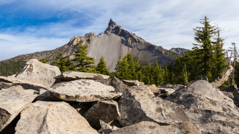 Mount Thielsen with a base of rocks and trees around its side