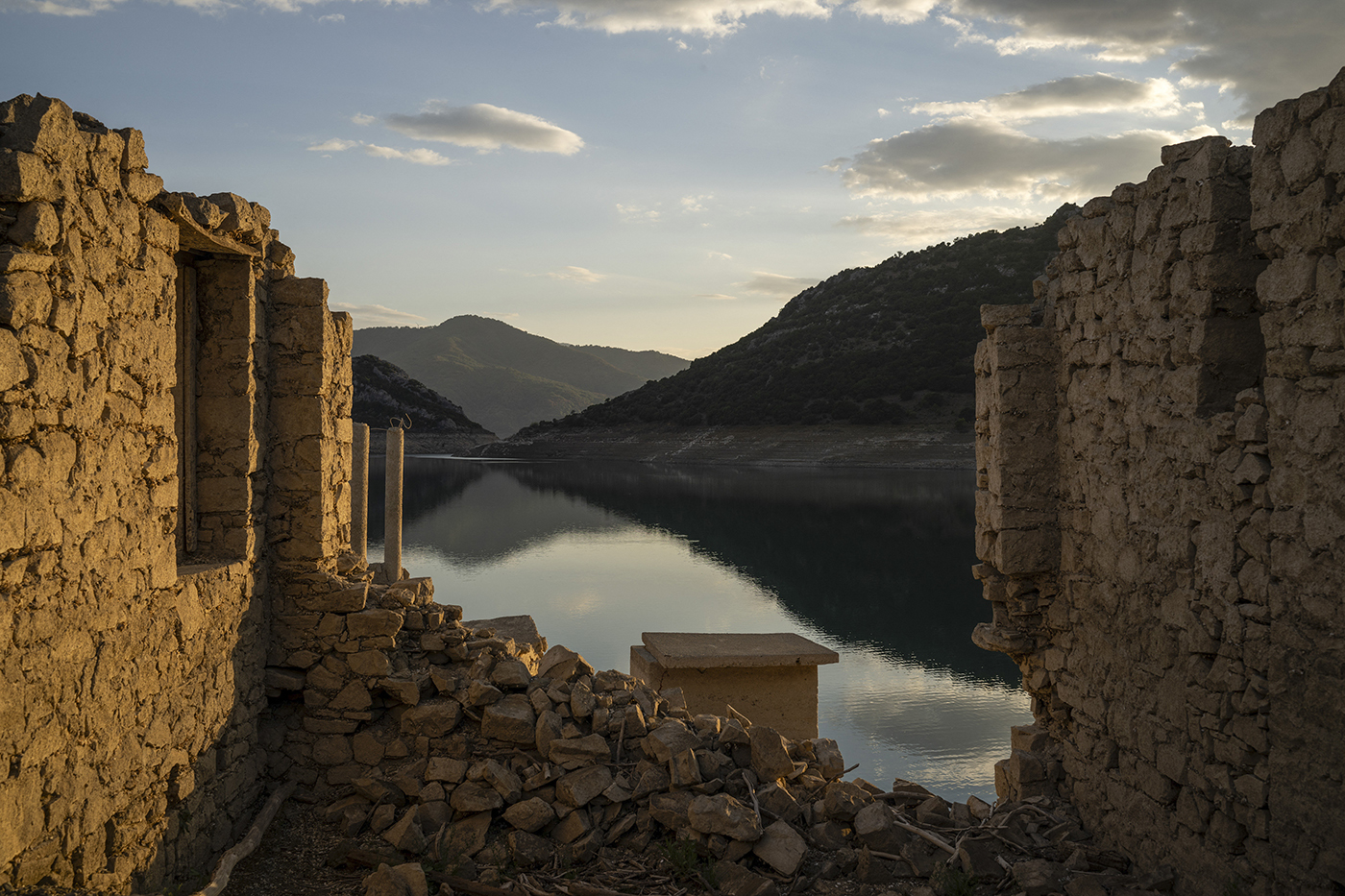 stone remnants of a house re-emmerge in a reservoir due to drought