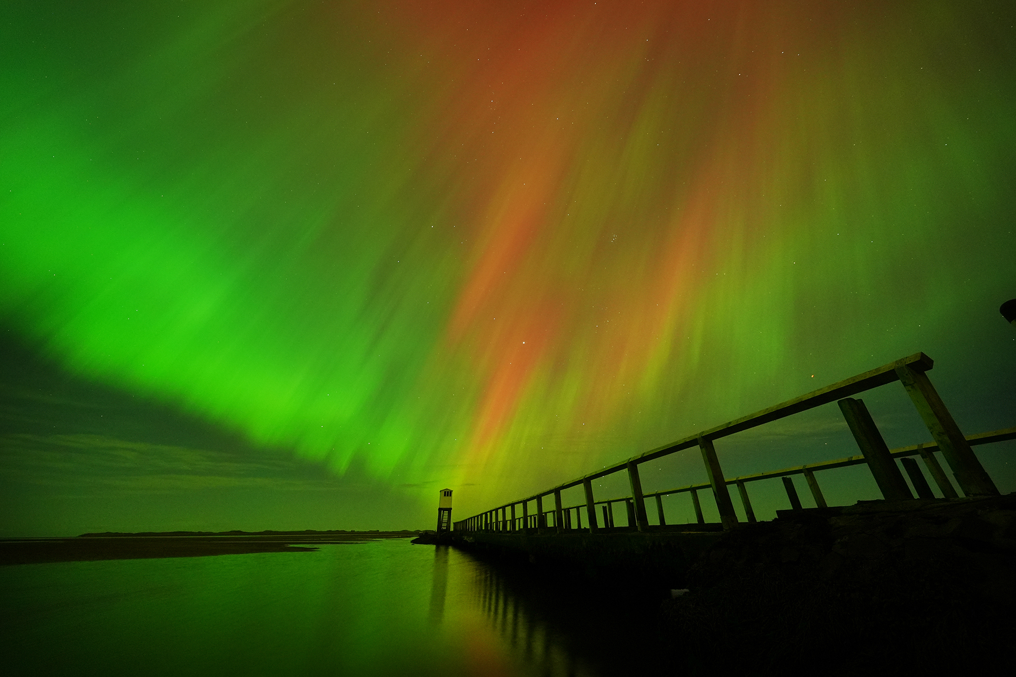 The Northern Lights, also known as the Aurora Borealis, seen in an incredible display in the skies over the refuge hut on the causeway leading to Holy Island in Northumberland, on the North East coast of England, in the early hours or Friday morning. Aurora displays occur when charged particles collide with gases in the Earth's atmosphere around the magnetic poles. As they collide, light is emitted at various wavelengths, creating colourful displays in the sky. Picture date: Friday October 11, 2024. (Photo by Owen Humphreys/PA Images via Getty Images)