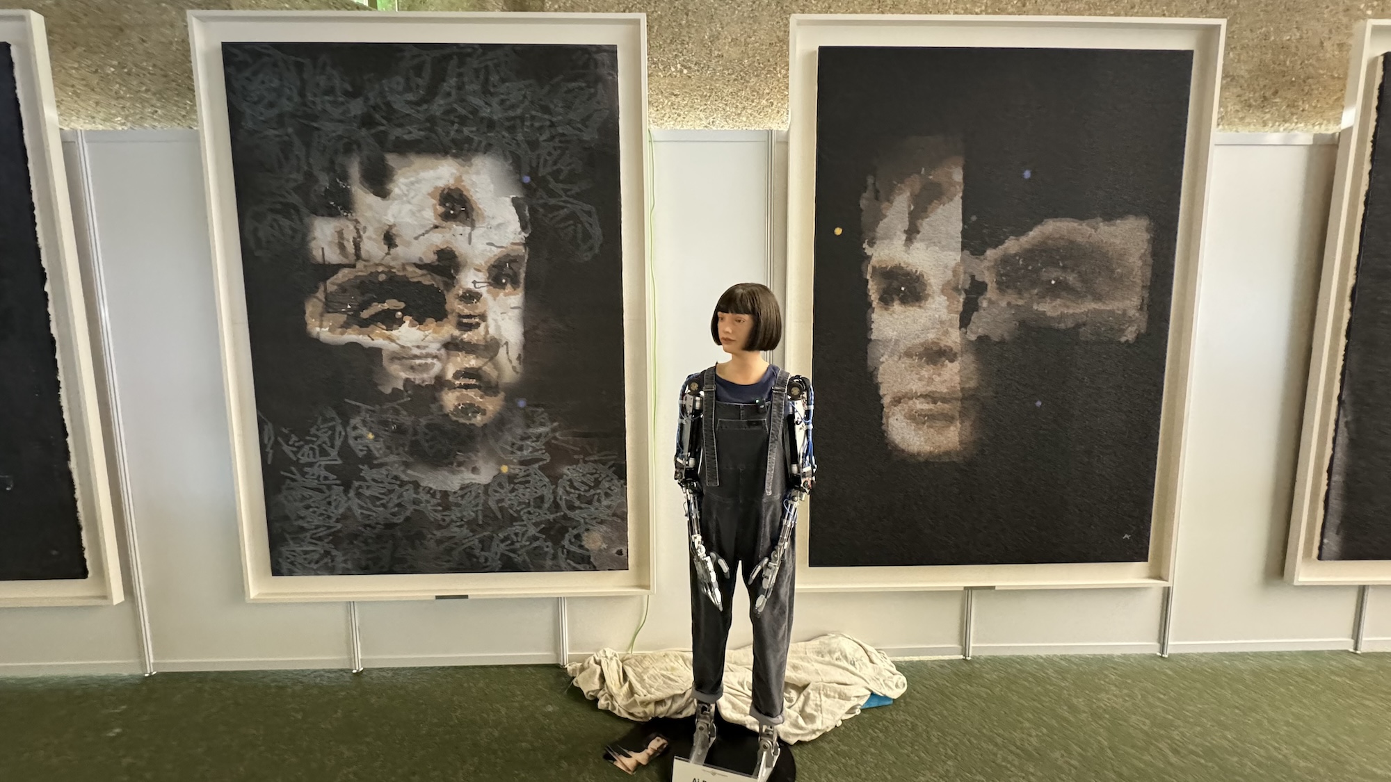 Ai-Da robot standing in front of two of its paintings at the United Nations